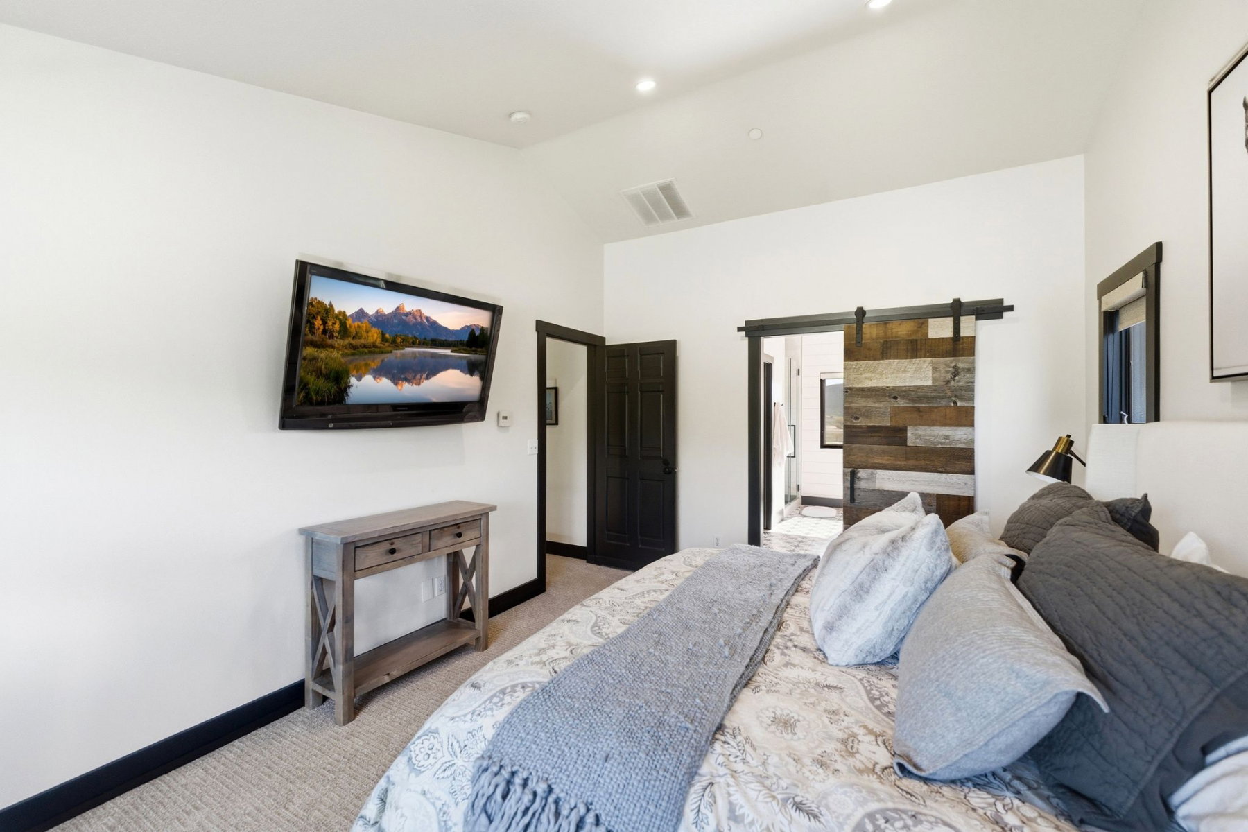 Room featuring a rustic barn door, recessed lighting, and dark trim