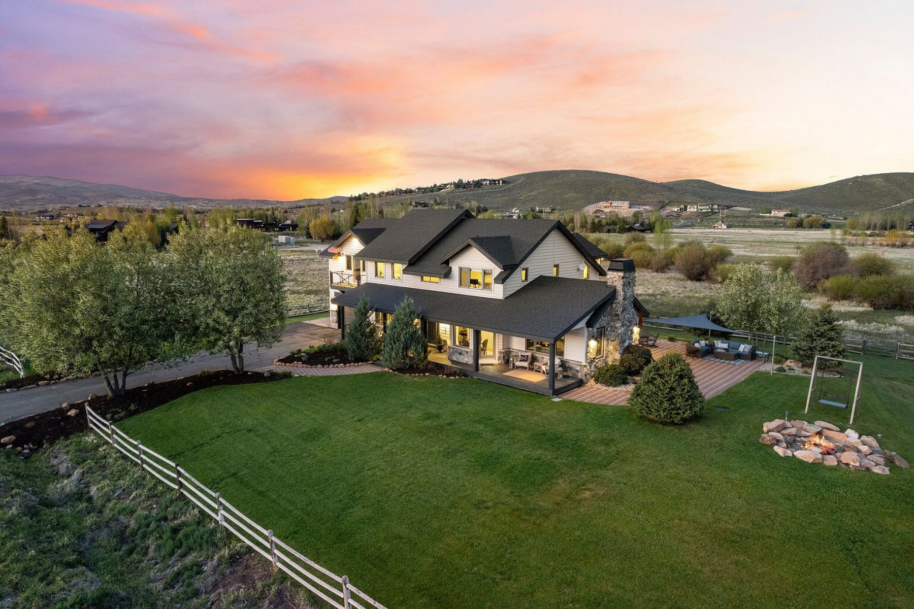 Expansive property featuring a large residence with a covered porch and a prominent stone chimney