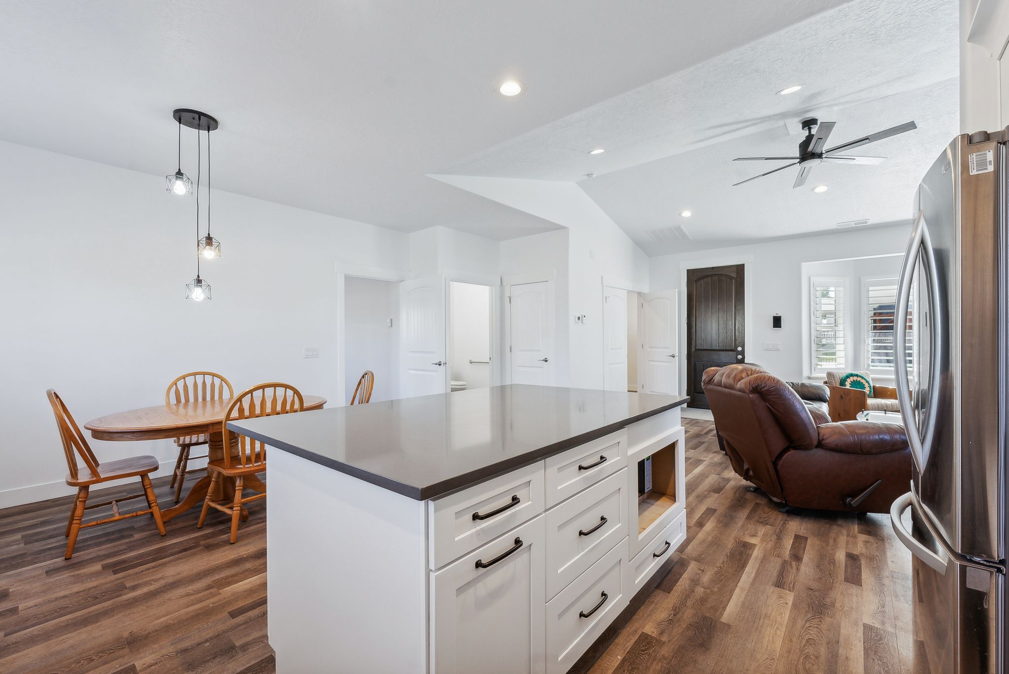 Custom built ADU/Kitchen island with white cabinetry and dark countertop