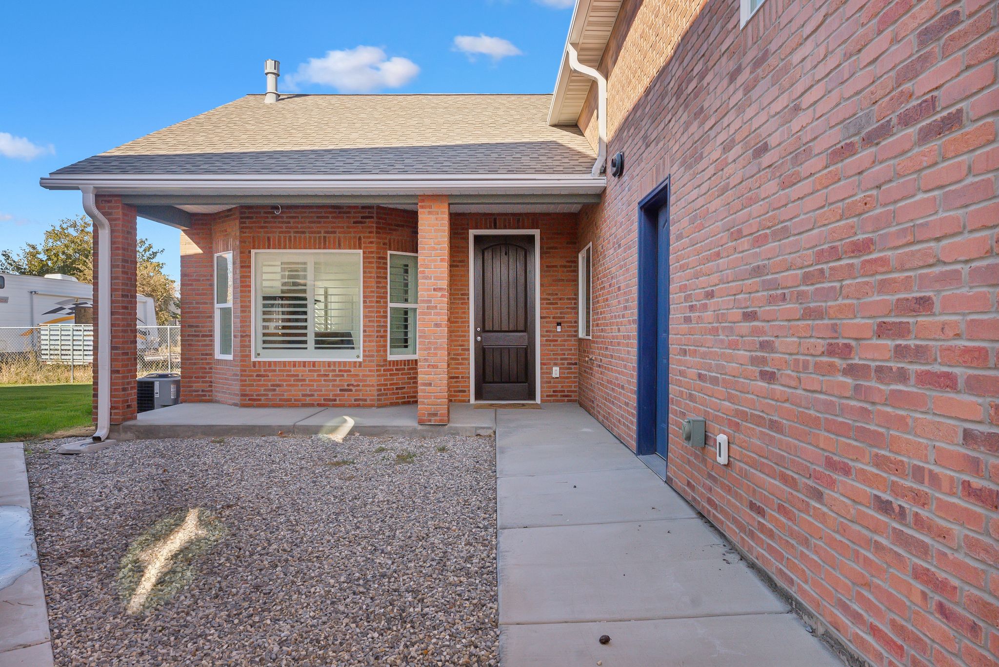 Custom built ADU/Brick exterior with covered front entry and dark wood-finish door