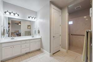 Bathroom featuring a double vanity with white cabinetry, dual sinks, and a large mirror