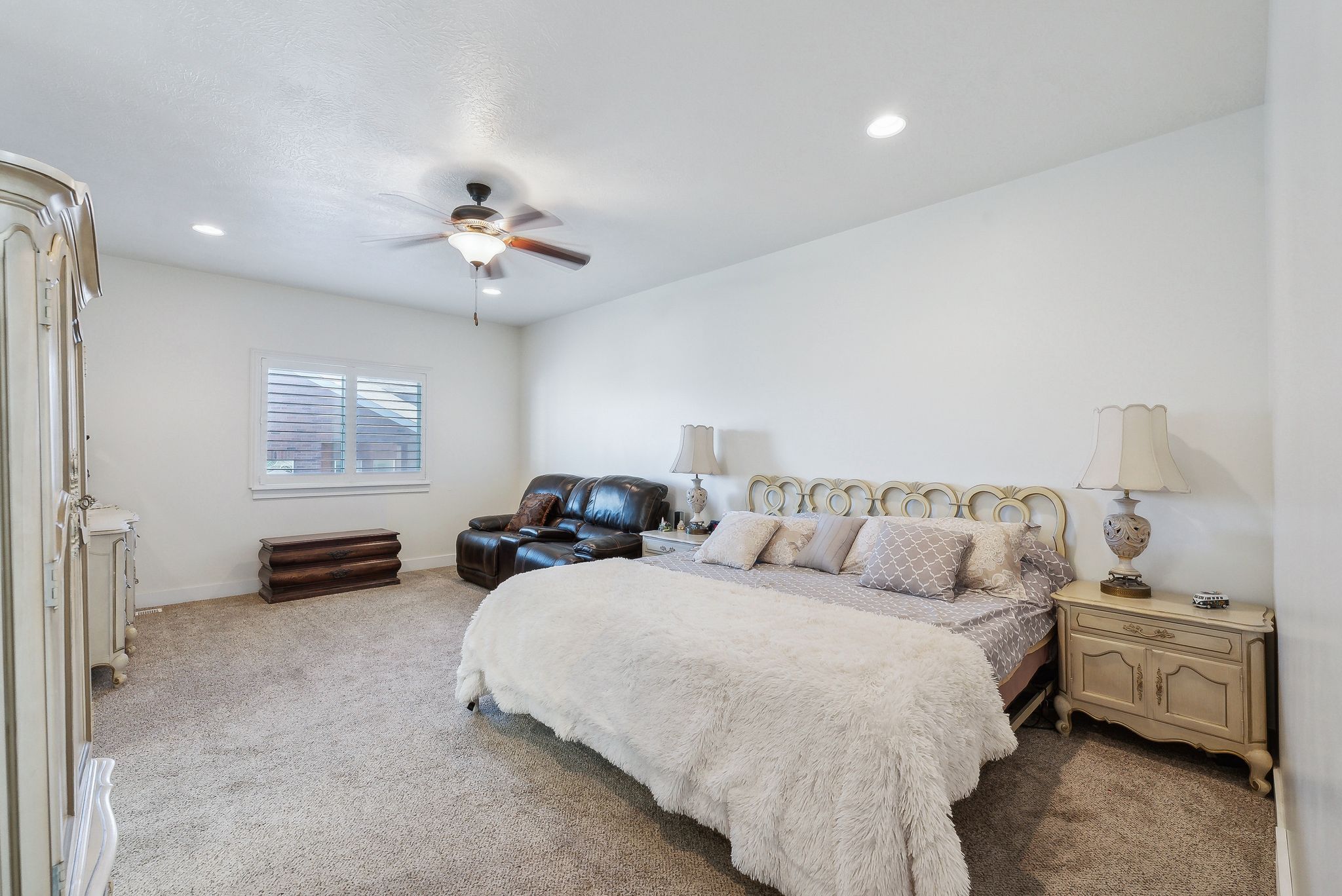 Spacious room featuring neutral carpeting, white walls, and recessed lighting
