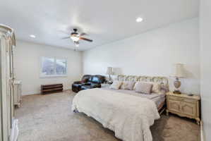 Spacious room featuring neutral carpeting, white walls, and recessed lighting