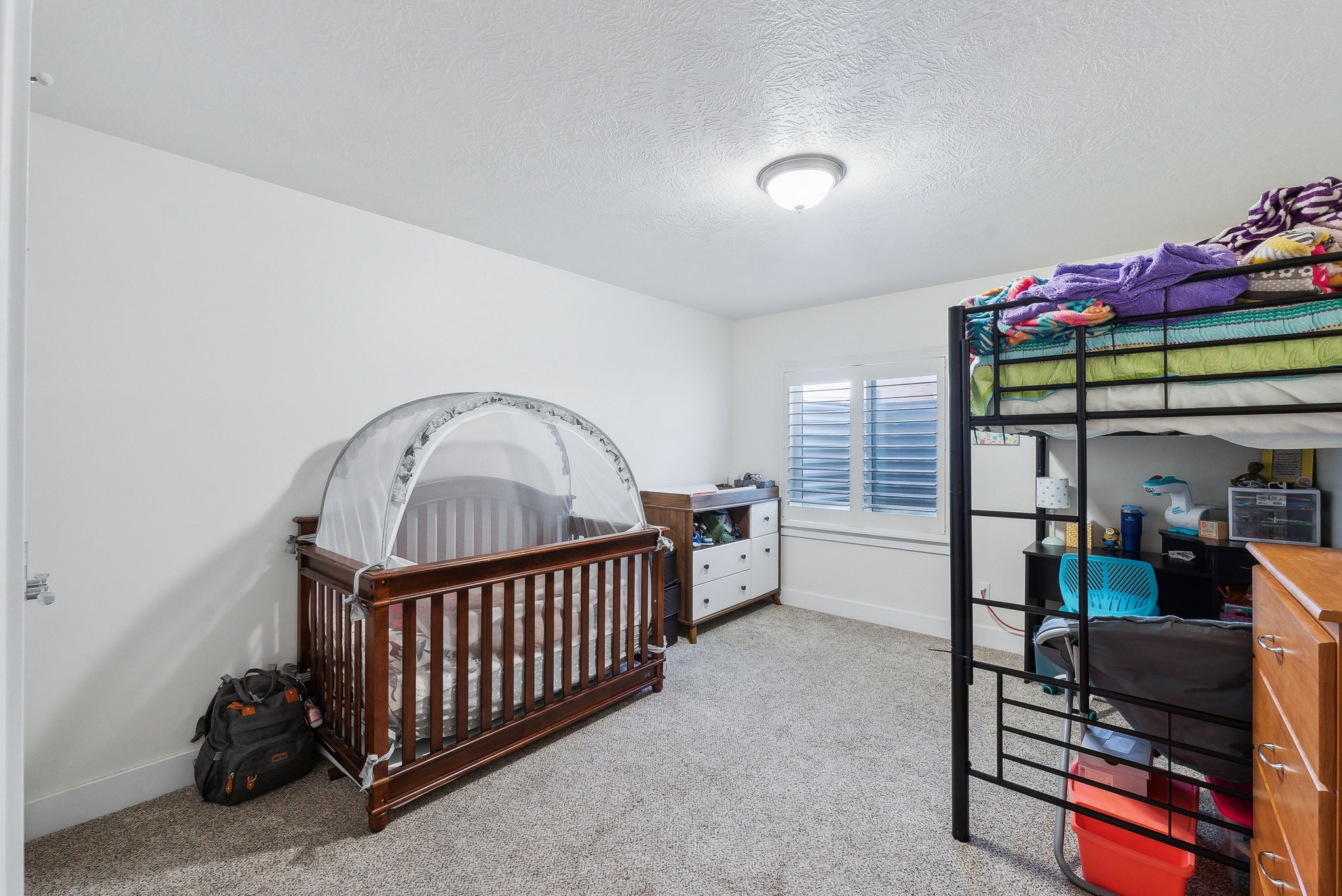 Room featuring light neutral wall paint, textured ceiling, and soft carpet flooring