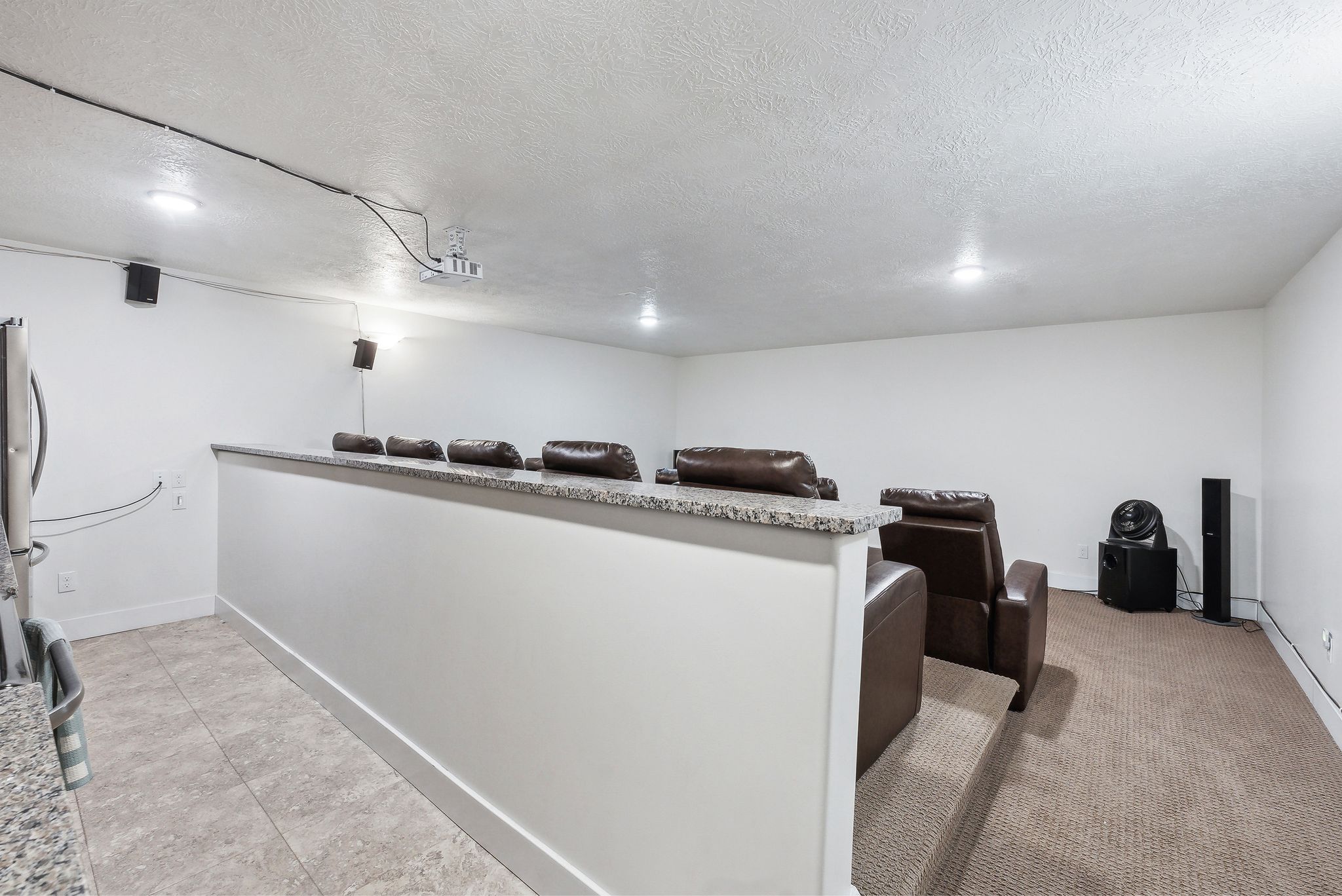Theatre with full kitchen/Carpeted entertainment area featuring a raised seating platform