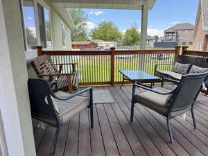 Expansive covered deck featuring composite decking and a wooden railing with black metal balusters
