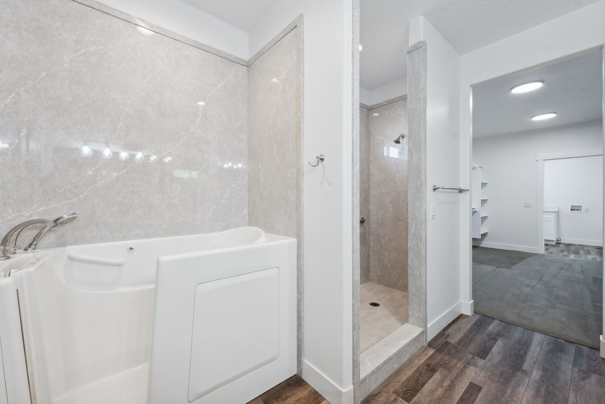 Custom built ADU/Bathroom featuring a walk-in tub and a separate shower with stone-look wall panels