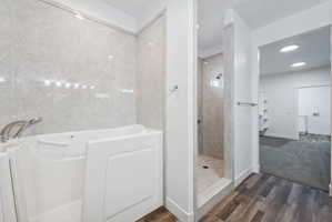 Custom built ADU/Bathroom featuring a walk-in tub and a separate shower with stone-look wall panels