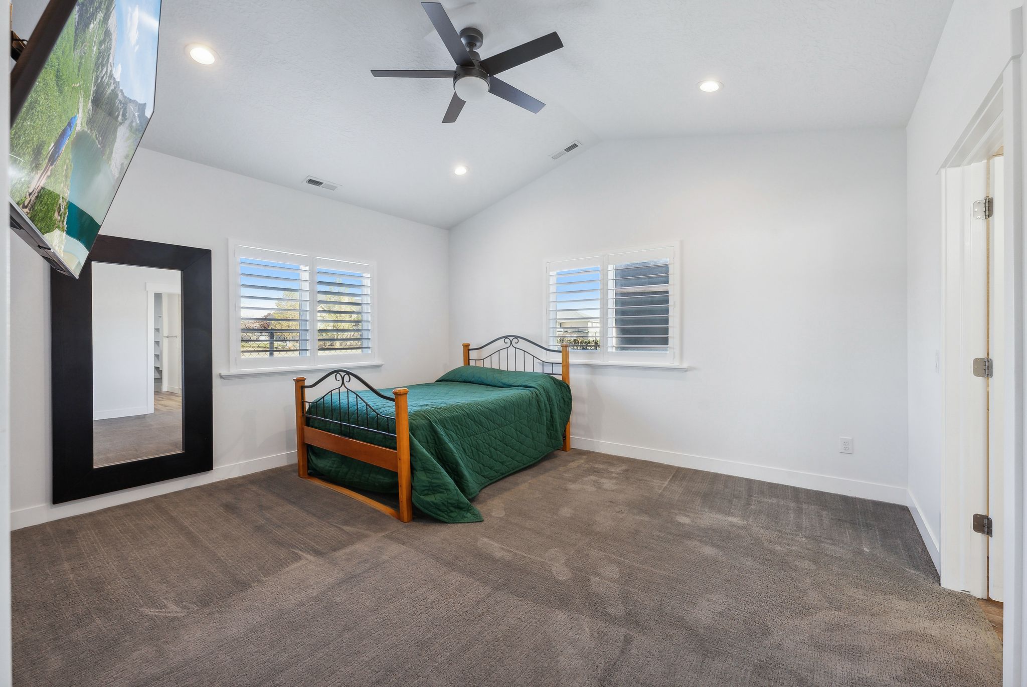 Custom built ADU/Spacious room featuring vaulted ceilings, recessed lighting, and soft gray carpeting