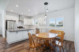 Custom built ADU/Contemporary kitchen featuring white cabinetry, stainless steel appliances, a center island with dark countertop, and wood-finish flooring