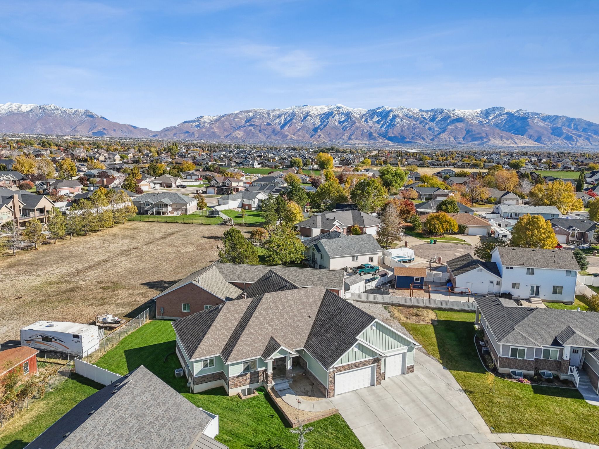 Aerial perspective showcasing a residential property with a multi-gabled roof and a two-car garage