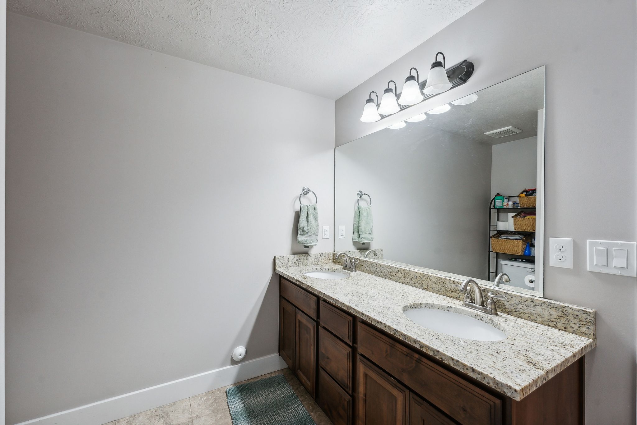 Double vanity with granite-style countertop, dual undermount sinks, and brushed nickel faucets