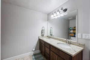 Double vanity with granite-style countertop, dual undermount sinks, and brushed nickel faucets