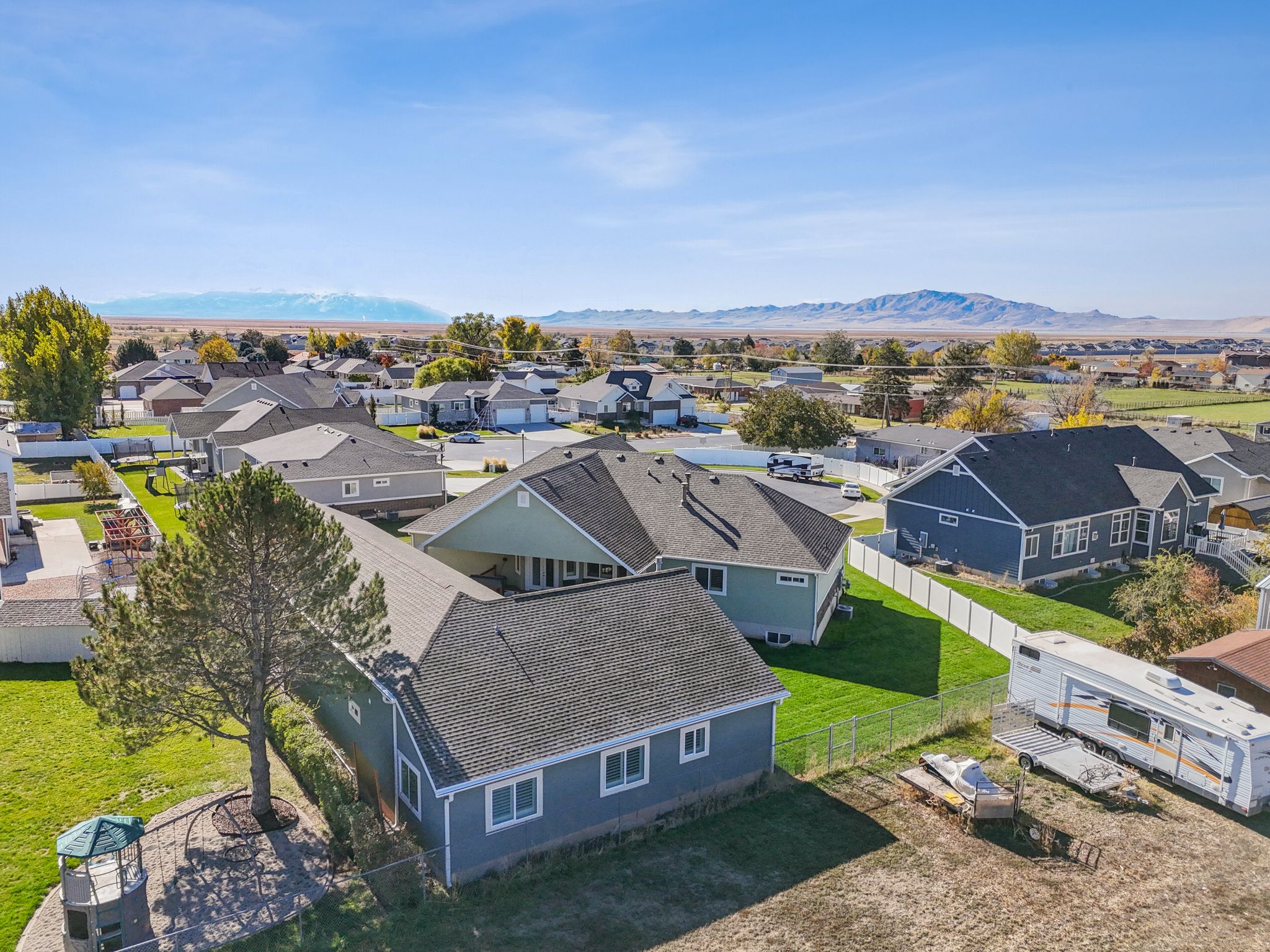 Expansive property featuring a spacious lot, established trees, and a mountain backdrop