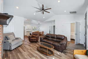 Custom built ADU/Open concept living area featuring vaulted ceilings, wood-finish flooring, recessed lighting, and a prominent ceiling fan