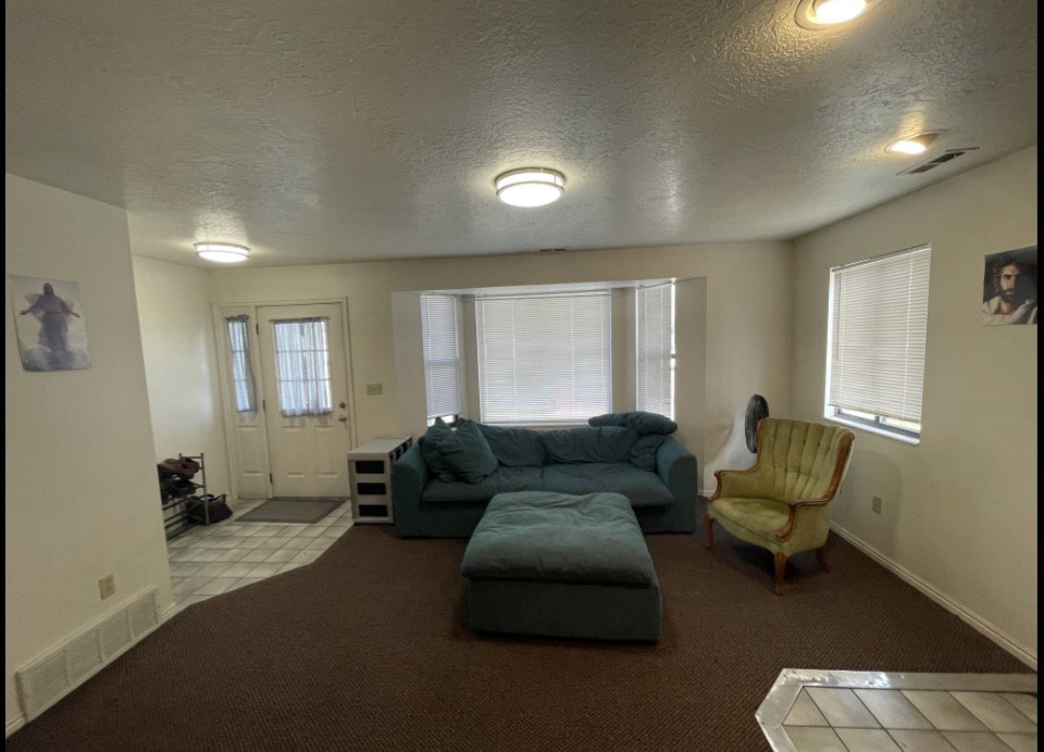 Living area featuring a bay window with blinds, recessed lighting, and a textured ceiling