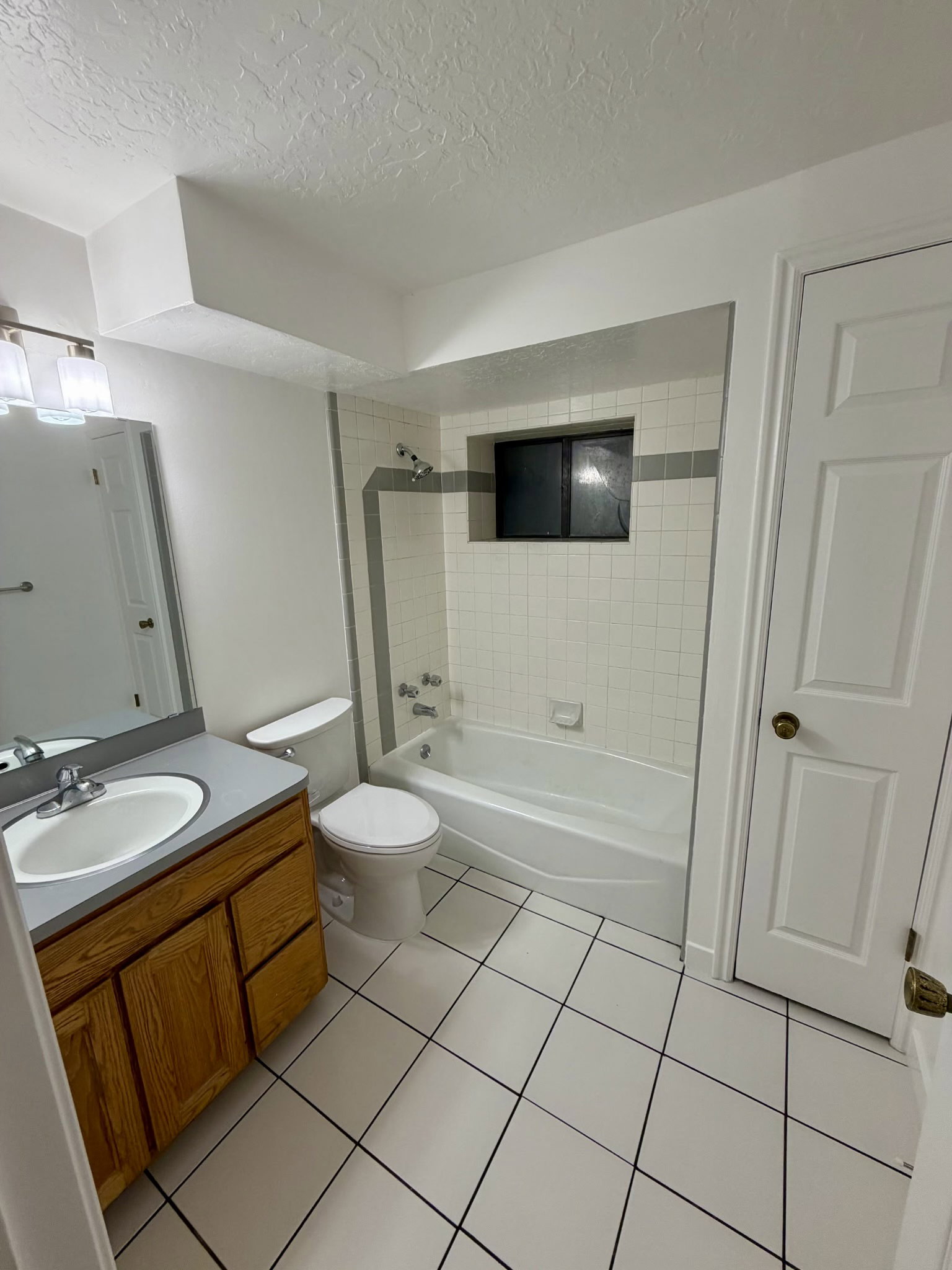 Bathroom featuring a full vanity with wood-finish cabinetry, a white porcelain sink, and a silver faucet