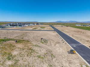 Expansive vacant land parcels featuring newly paved roads and clear skies