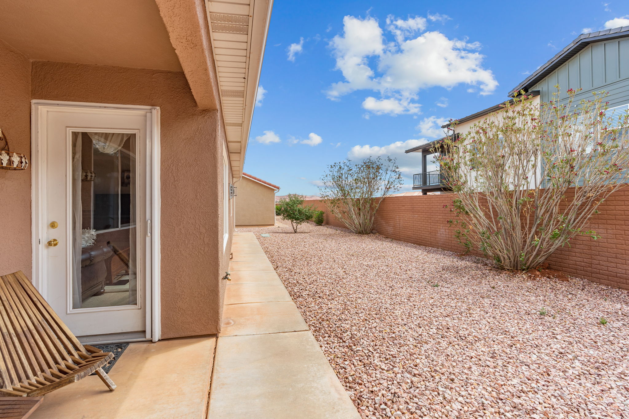 White paneled glass door with brass hardware set into a stucco exterior