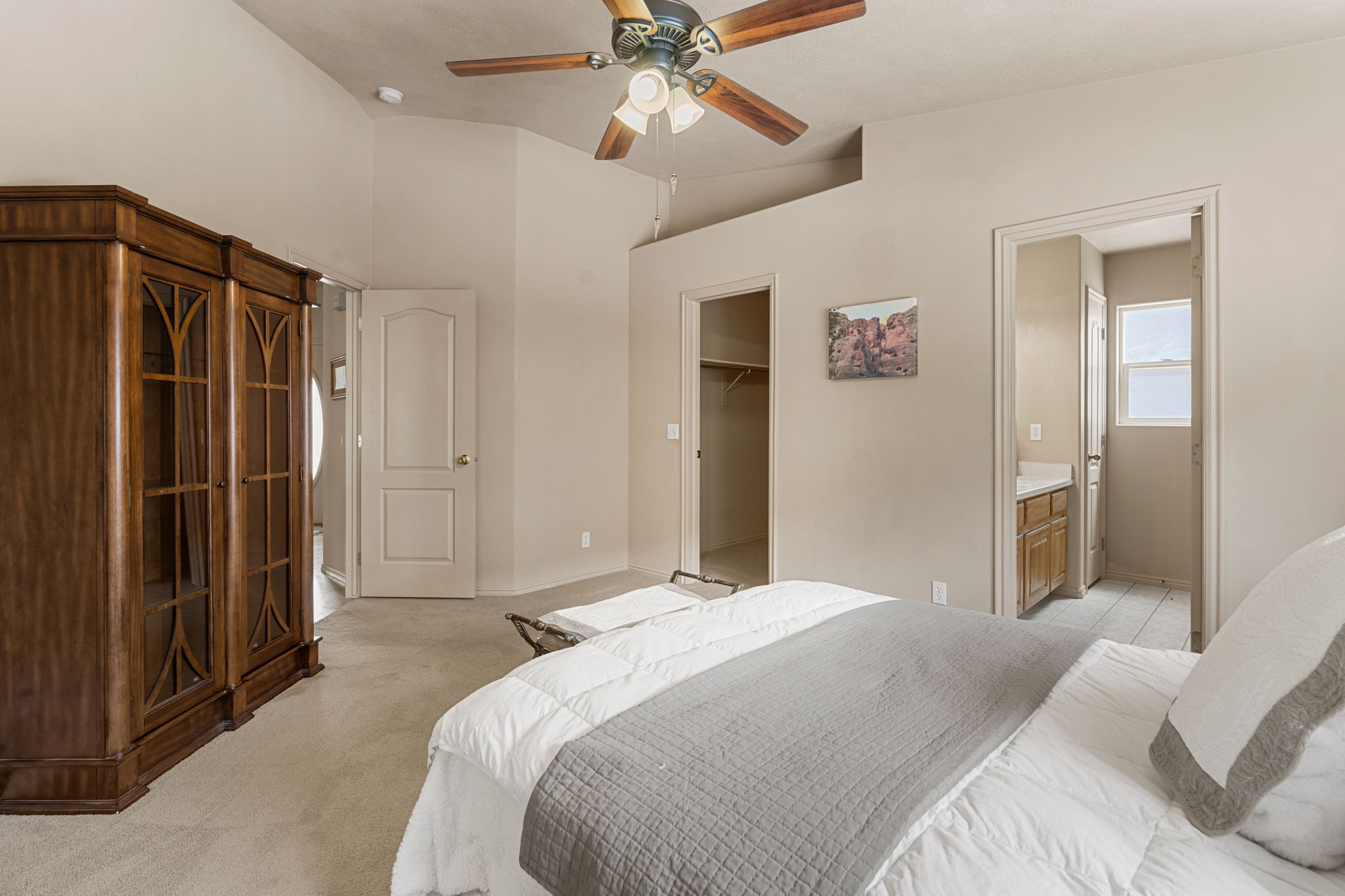 Carpeted interior with vaulted ceilings and a ceiling fan