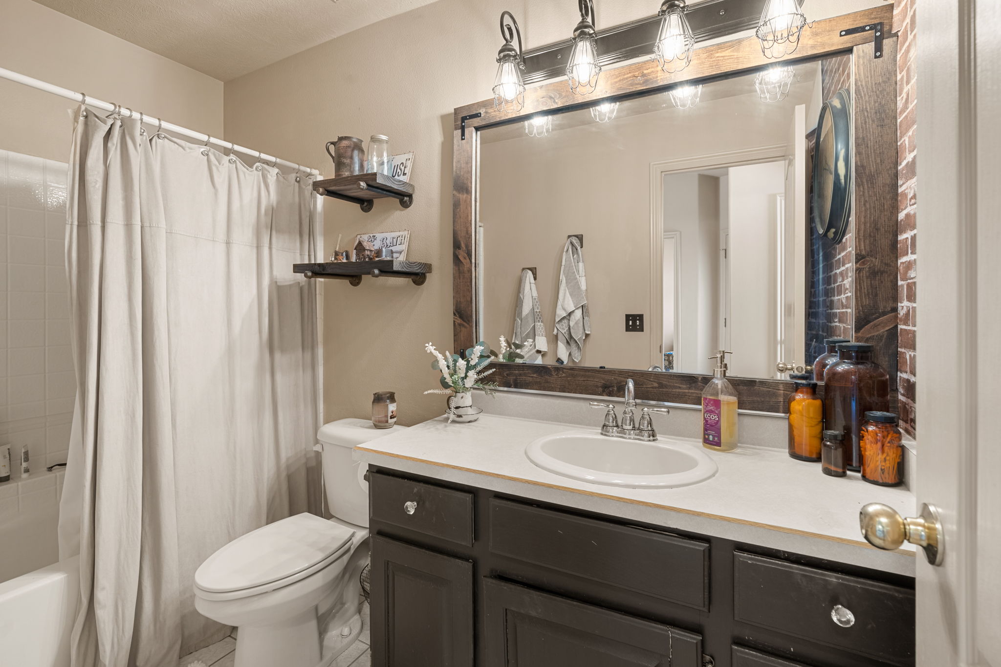 Bathroom featuring a vanity with dark wood cabinetry, white countertop, and an oval undermount sink