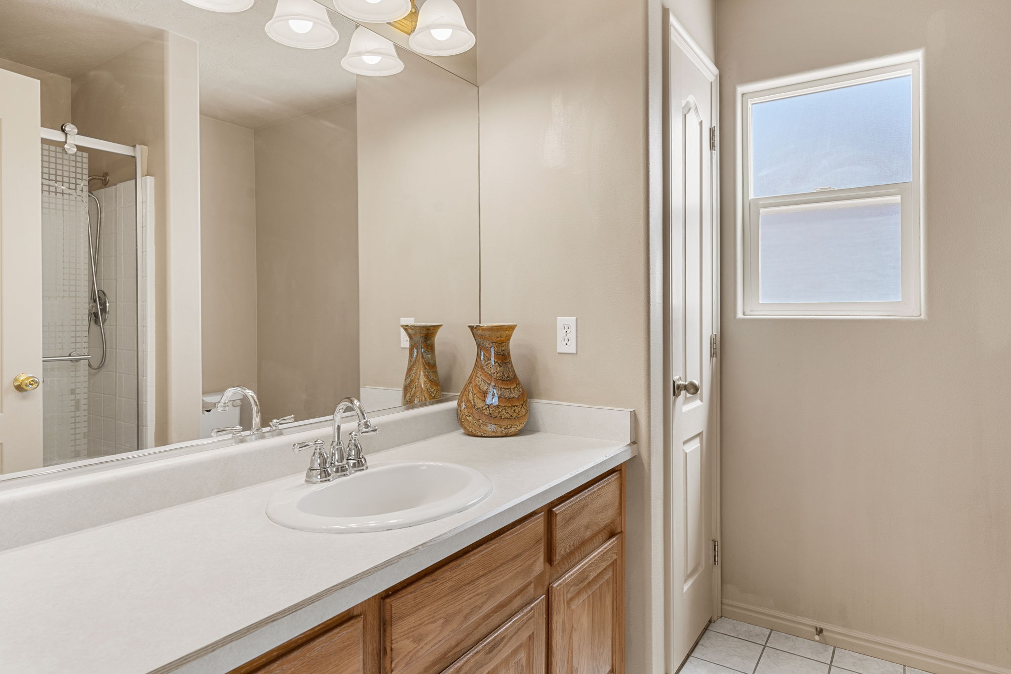 Bathroom featuring a single vanity with wood cabinetry, a white countertop, and a chrome faucet