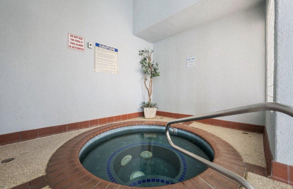 Indoor spa with brick coping and a polished metal handrail