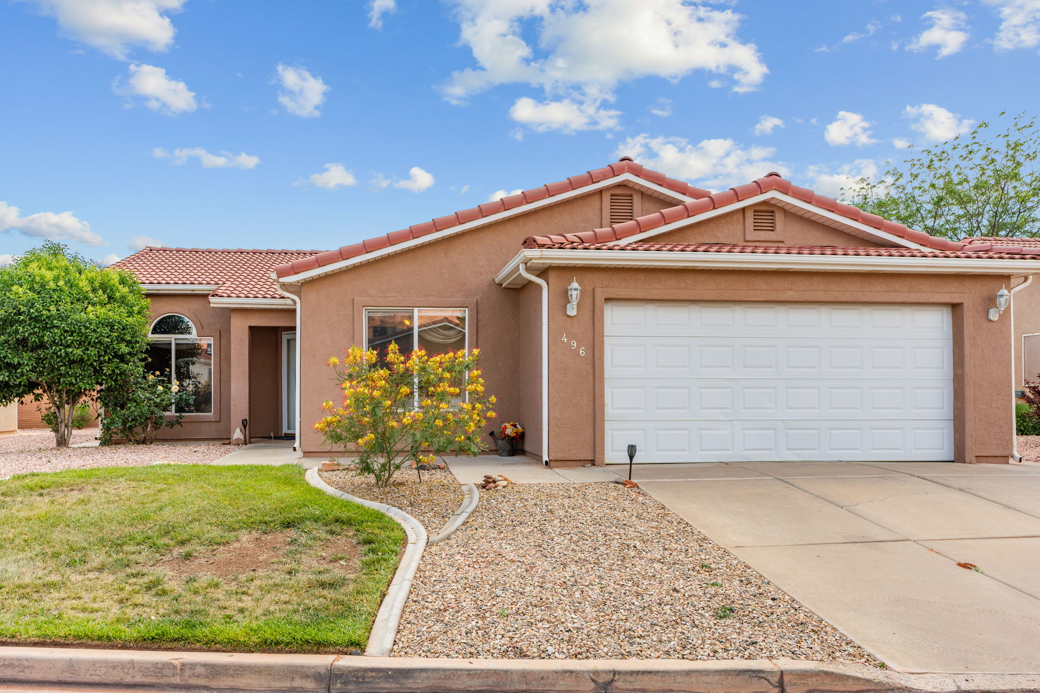 Southwestern style exterior with a tile roof, stucco finish, and an integrated two-car garage