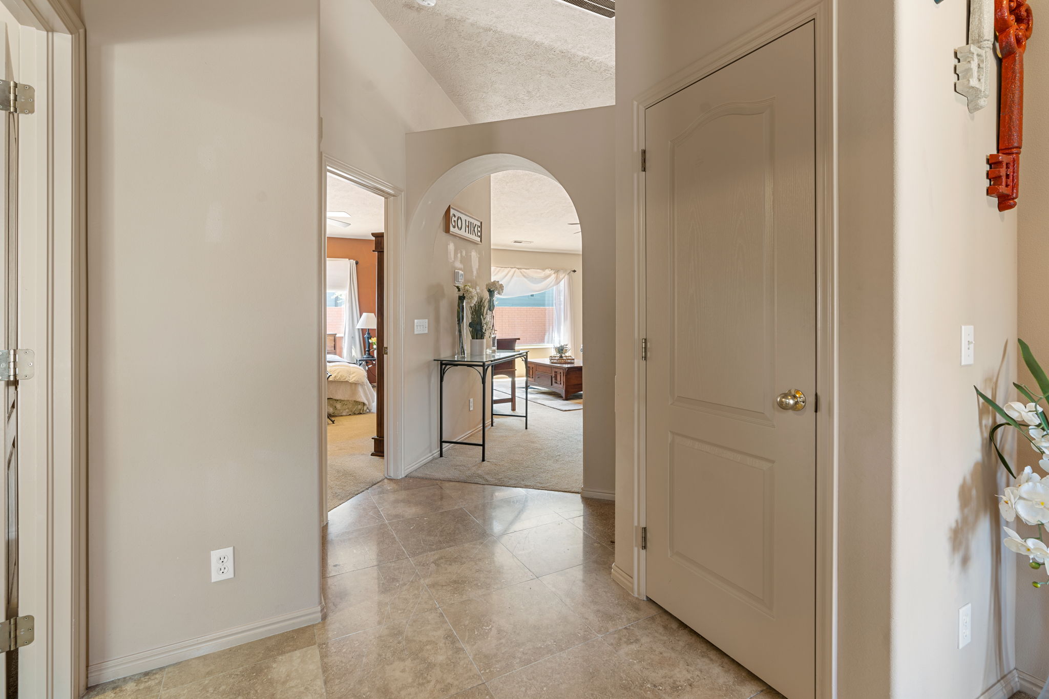 Tiled entryway featuring an arched doorway, paneled interior doors, and neutral wall tones