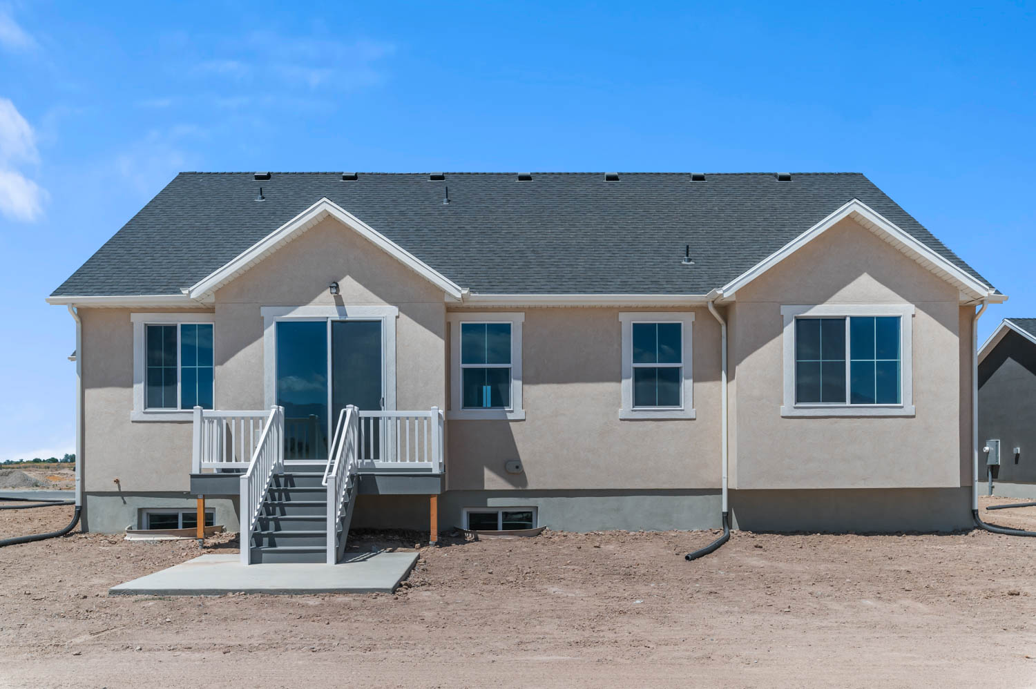 Rear elevation featuring a sliding glass door and deck with white railings