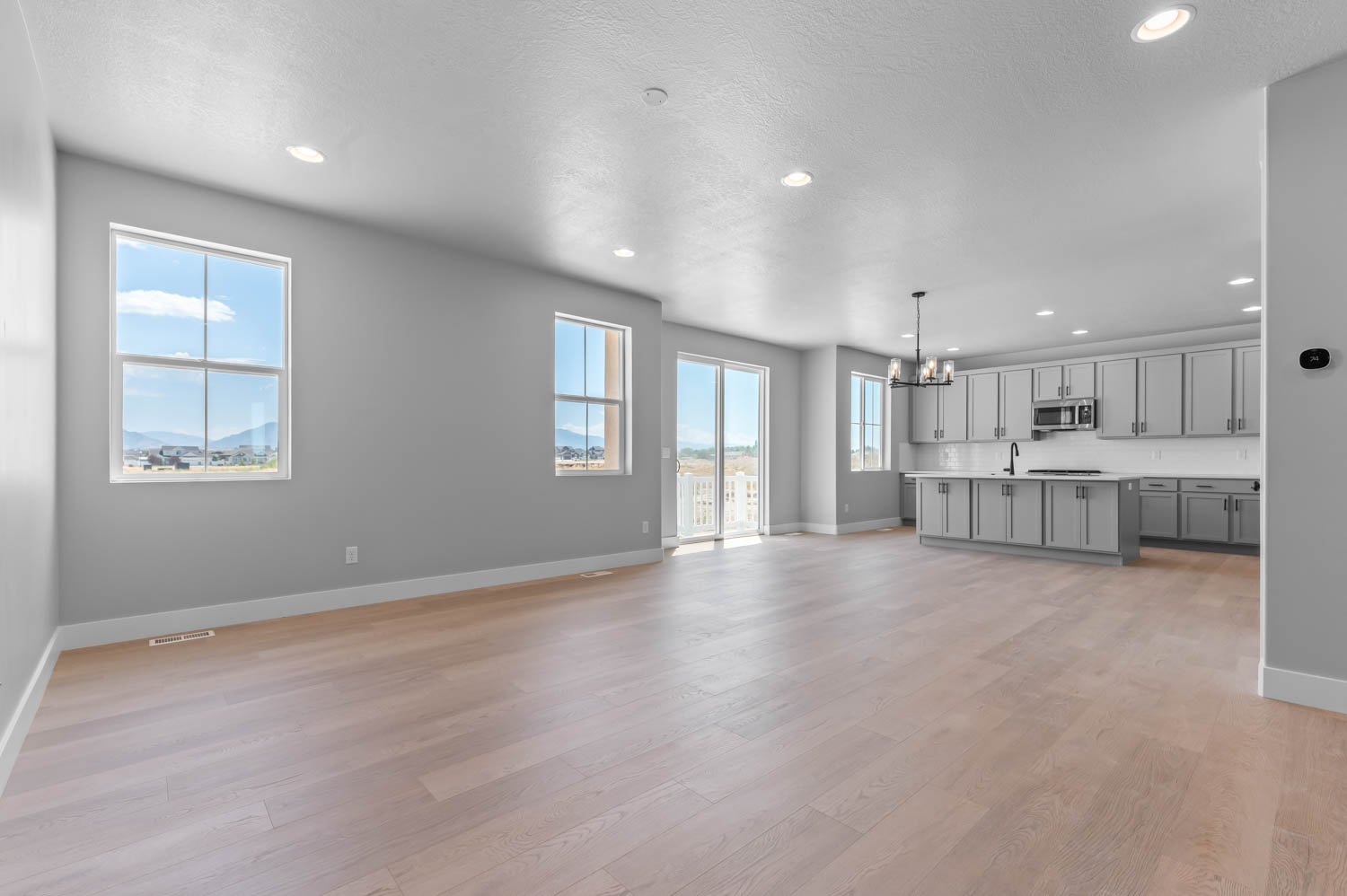 Open-concept living space featuring light wood-finish flooring, recessed lighting, and neutral wall tones