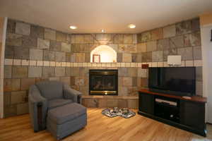Fireplace featuring a stone tile surround, a built-in arched alcove with recessed lighting, and a hearth