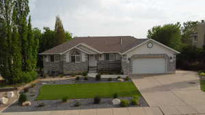 Single-story residence featuring a two-car garage, stone and stucco exterior, and a paved driveway