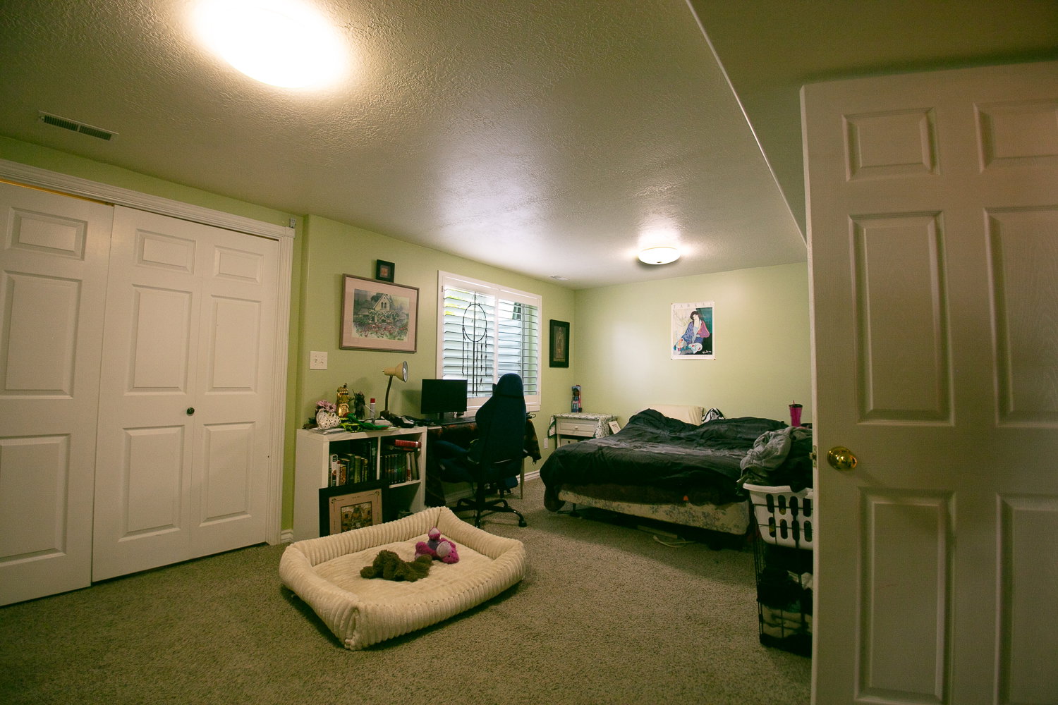 Carpeted room featuring a double-door closet with paneling