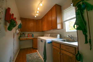Dedicated utility room featuring wood-finish flooring and extensive wood cabinetry