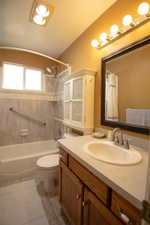 Bathroom featuring a wood-finish vanity with a light-toned countertop and an oval sink