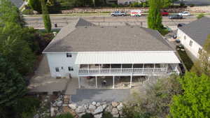 Spacious property featuring a large composite shingle roof, white exterior siding, and a covered upper-level deck with white railings