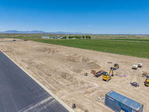 Expansive undeveloped lot featuring clear land, mountain backdrops, and established agricultural fields