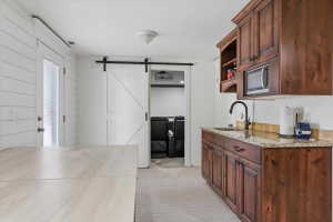 Wet bar featuring rich wood cabinetry, granite countertop, and integrated microwave