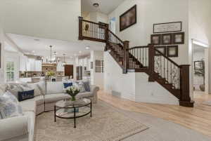 Grand entryway featuring a dark wood staircase with wrought iron balusters and light wood-finish flooring