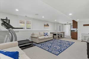 Spacious recreation area featuring recessed lighting, white shiplap wainscoting, and carpet flooring