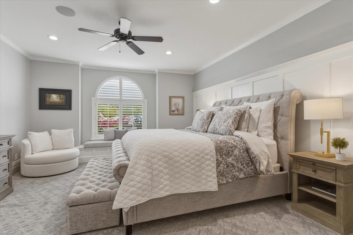 Bedroom featuring a large arched window with plantation shutters, recessed lighting, and crown molding