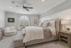 Bedroom featuring a large arched window with plantation shutters, recessed lighting, and crown molding