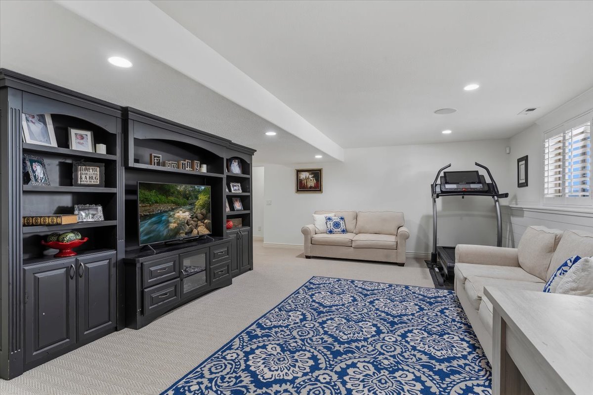 Expansive living area featuring a custom dark wood entertainment center with built-in shelving and cabinetry