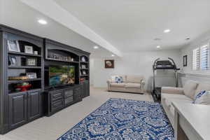 Expansive living area featuring a custom dark wood entertainment center with built-in shelving and cabinetry