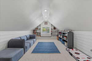 Finished attic space featuring recessed lighting, a window with plantation shutters, built-in shelving, carpet flooring, and shiplap wall detailing