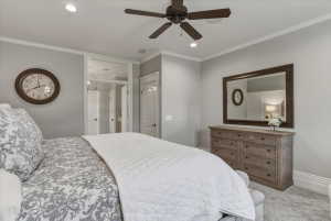 Neutral-toned bedroom featuring crown molding, recessed lighting, and a ceiling fan