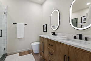 Double vanity with wood-finish cabinetry and black hardware