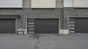 Modern garage doors set against a dark brick facade