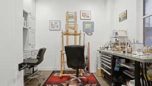 Built-in white cabinetry with a desk area, hardwood flooring, and a large window providing ample natural light